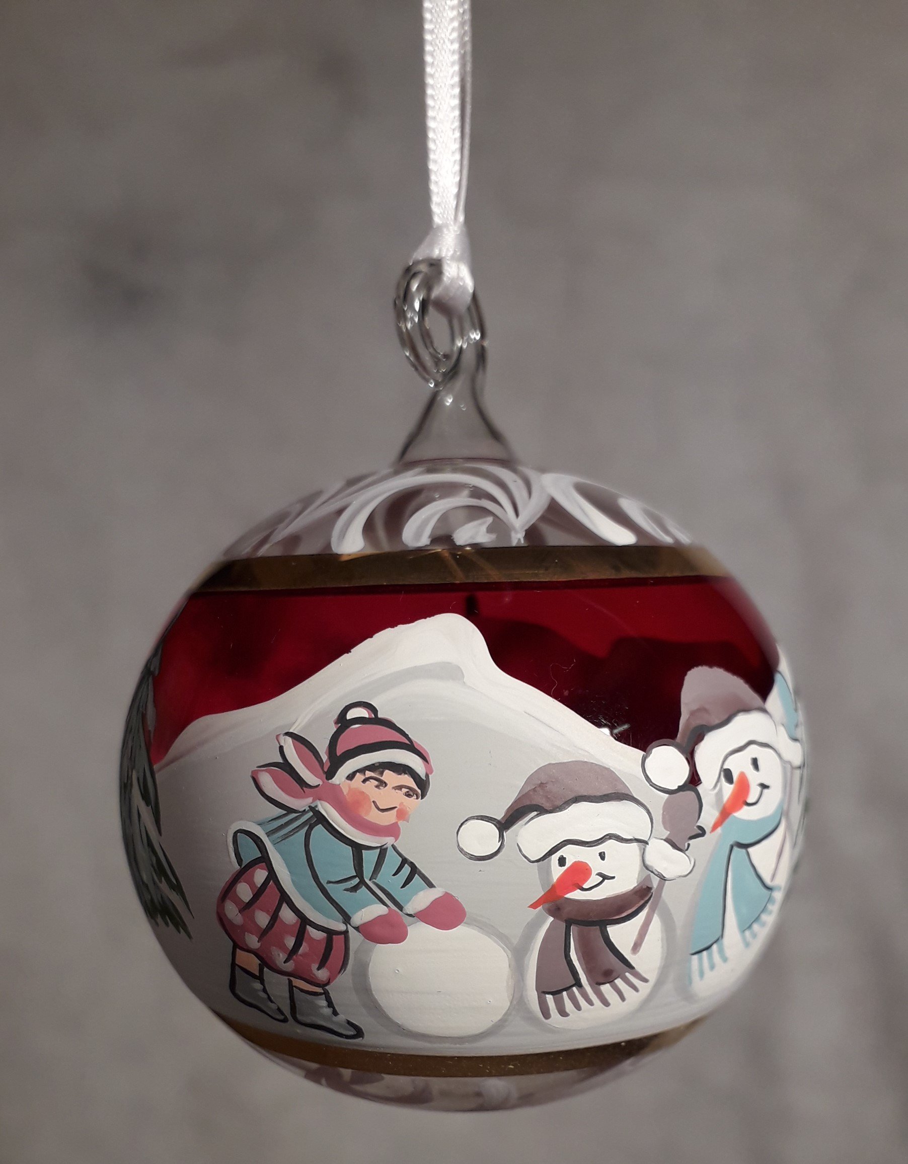 Bimba con 2 pupazzi di neve rosso